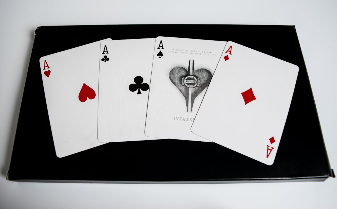 High-quality image of four aces from a deck of playing cards on a black surface.